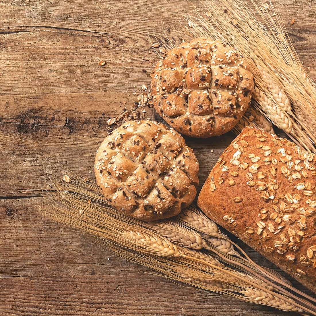 Wheat grains and baking ingredients on a wooden board